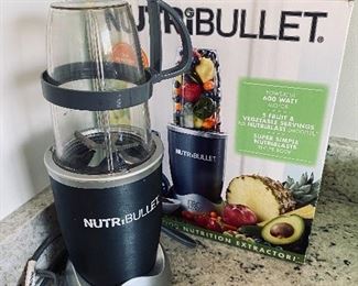 Lot 5540. $26.00 Nutribullet set with box, includes; power base, short cup with a handled ring, tall cup, extractor blade, 1 lip ring, and a care booklet.