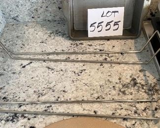 Lot 5555. $35.00 This lot features a "like new" 13" Pampered Chef pizza stone and two metal carrying racks; 2 Food Network Pie Pans and an 8" square metal dish.