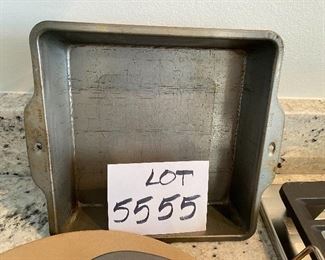 Lot 5555. $35.00 This lot features a "like new" 13" Pampered Chef pizza stone and two metal carrying racks; 2 Food Network Pie Pans and an 8" square metal dish.