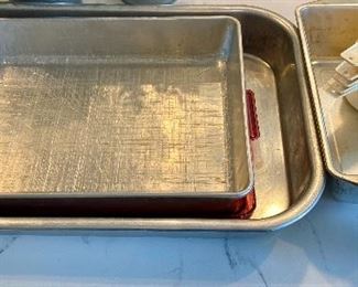 Lot 5565. $22.00 Set of 4 items, Aluminum loaf pan, 9x12 covered cake pan, Another 12x19 cake pan and 5 Tupperware Measuring Cups
