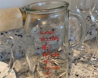Lot 5572. $40.00 Pampered Chef 2 Qt - 8C measuring bowl with lid in excellent condition ; 2) Polished metal Banana holder ; 3). Cute Vintage Glasco measuring pitcher with mixing pump. 4 ) Cloth Covered Rolling Pin