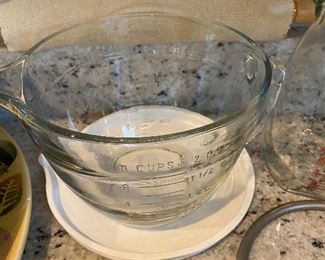 Lot 5572. $40.00 Pampered Chef 2 Qt - 8C measuring bowl with lid in excellent condition ; 2) Polished metal Banana holder ; 3). Cute Vintage Glasco measuring pitcher with mixing pump. 4 ) Cloth Covered Rolling Pin