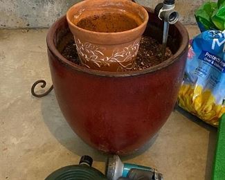 Lot 5627 $45.00 Garden Special (Spring Please Arrive Early!) includes: Wrought Iron Plant Stand; Large Brown Ceramic Pot, 2 Green Knee Pads, Nozzle and 2 Sprinklers, another terra cotta smaller pot