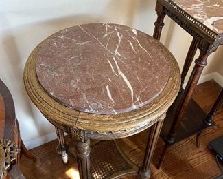 Antique round marble top table on a wooden base with a caned shelf at the bottom.  17 inch diameter by 29 1/2 inches high.  $280