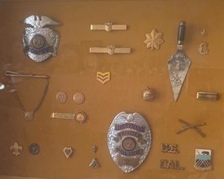 Framed collection of vintage badges & pins. 