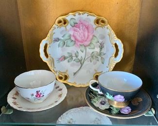 Naomi Hawkins 1964 decorative plate 8.5” W x 8”H. RW Bavaria Made in Germany (8404) black floral cup and saucer - Cup 2”H; saucer 5.75”D. Bone China Crown Staffordshire cup and saucer. Cup 2”H; saucer 5.5”D