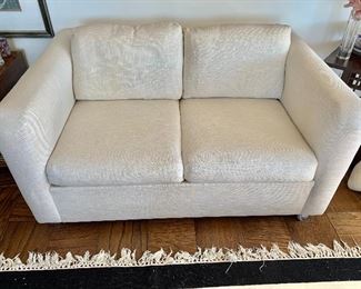 $250. Sealty Connecticut Furniture cream colored linen look two cushion loveseat on castors. AS IS - small tear behind left pillow and slight stain -  27"H x 55"W x 36"D (seat height 18"H)