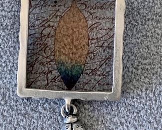 $20 - Glass and silver tone pin with ladybug pendant; 2” H x 1” W 