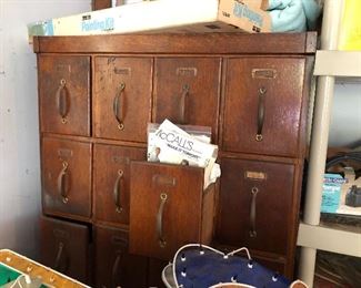 Cool vintage drawer wooden cabinet filled with sewing patterns!