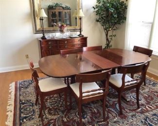 Dining table and chairs, sideboard and thick wool rug. 