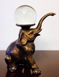 Bronze Elephant figurine balancing a glass ball. This adorable little elephant measures 4” wide and 7” high.