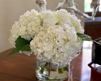 $70 - Faux composed white hydrangea and rose bouquet in clear cylindrical vase. 9.5" H x 12" diameter