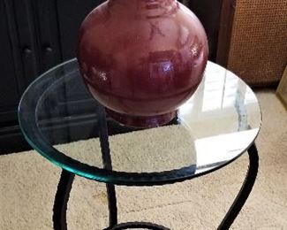Round glass side table and burgundy vase