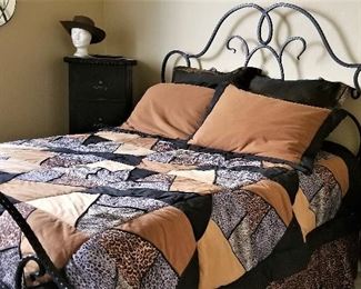 Queen wrought iron bed along with the queen leopard comforter set in blacks, silvers, browns and golden bronze.