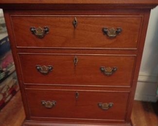 small mahogany dresser with three keys