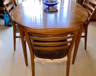 Lot 6003 $400.00. MCM Heritage Oval Dining Table with 6 Chairs (4 side and 2 armchairs). Includes: 2 Leaves each 18"w. Beautiful wood, appears to be Cherry or Pecan? Awesome inlay looking design. 6 Chairs, 58"x45" without leaves in. Chairs need new coverings,