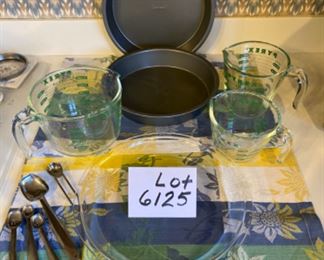 Lot 6125. $33.00. Pyrex 10" glass pie plate, 2 Chefmate non-stick cake pans, 2 pyrex measuring pitchers with green writing, vintage measuring spoons.