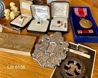 Lot 6156. $75.00. Lot of Random but cool items: 1.Univ. of Miami Heritage Society Paperweight, 2, The Great Seal of State of Montana Pewter Gelt Buckle c.1986, 3, Three little resin figurines, 4. 3 tie pins - one tiger eye, one genuine mother of pearl and one onyx or similar, 5, Tie clip by Hickock, 6.One Replica of Gold Bar (heavy), 7. Good Conduct Medal from WW2, c. 1944 in Box, 8. Pewter Belt Buckle Crest, 9. Clan Crest Murray Clan - Scotland, 10. Photo of W.C. Fields