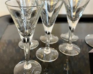 Lot 6182. $28.00 Thirteen Vintage Crystal Glasses. (4.25"t) and one larger pilsner glass in a coordinating pattern (8.5"t) with a starburst design. Vintage Glasses. 13 cordial glasses (4.25"t) and one larger pilsner glass in a coordinating pattern (8.5"t) with a starburst design.