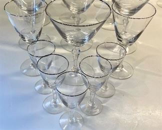 Lot 6191. $40.00. Ten Fostoria clear stems w/silver rim for champagne or sorbet (5.5"t) with 2 larger cordial (5.25"t) and 5 small cordials