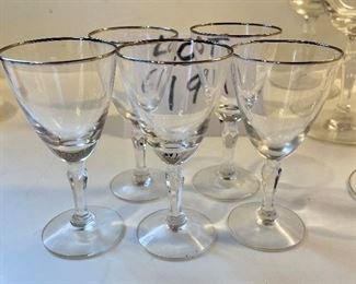 Lot 6191. $40.00. Ten Fostoria clear stems w/silver rim for champagne or sorbet (5.5"t) with 2 larger cordial (5.25"t) and 5 small cordials