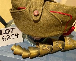 Lot 6204. $25.00 Youth or Man's Hat, vintage with button over top in a military khaki green with red trim and tassel, and set of Brass Bells, (7) in staggered sizes and sounds - hang in door opening. Vintage.