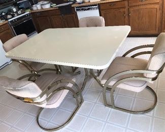 Milo Baughman Brass Cantilever  Style Mid-century dining table. Measures 60”L x 38”W.  Comes with 4 upholstered chairs. 