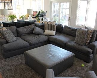 Large sectional sofa and a leather ottoman style coffee table.