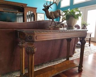 On top of the sofa table is a bronze elk sculpture