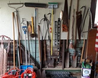 Room full of garden tools rakes shovels extension cord brooms pry bars
