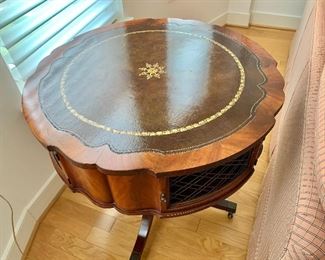 $350 - Vintage pedestal table with four doors and leather top on casters; 30 1/2"H x 32" diameter