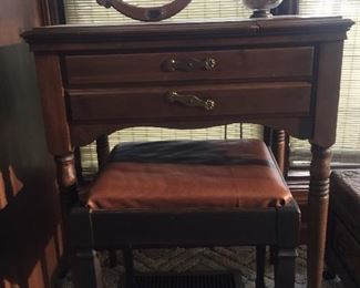 Antique sewing machine in wooden cabinet. Includes bench. 