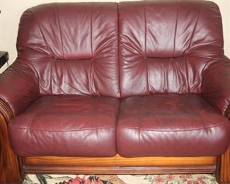 All leather love seat with wood frame.