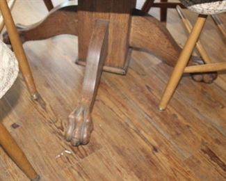 Round oak table with claw feet and oak chairs.