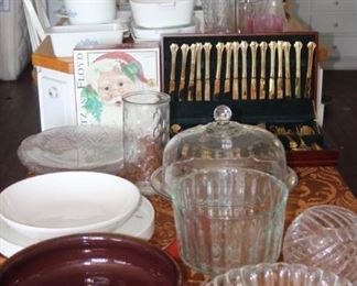 Tables of serving dishes, gold colored flatware, Fitz and Floyd Christmas bowls.