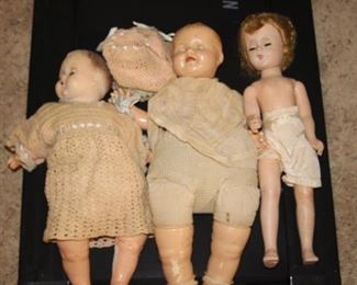 Three antique dolls with some clothing.
