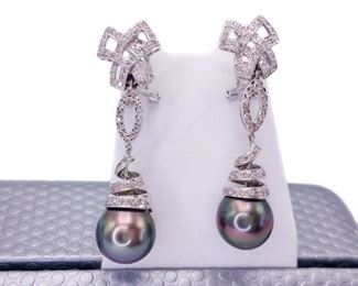 Every lady needs a set of pearls and WOW!! does this auction feature a spectacular set of Tahitian Pearls earrings that have high luster and sheen. Not to mention these pearls are 12-13 mm. The earrings also have 18k White Gold bows, ovals, and spiral s connecting to each large pearl that is covered with 1+ ctw of Diamonds...... because of course, diamonds are a woman's best friend and every lady needs a set of pearls. The set is shown in photos 2 and three, in this lot you are bidding solely on the earrings.