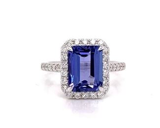 A 3.00 carat, high-grade emerald cut natural Tanzanite seems just flawless when it is beautifully bordered by spectacular high grade Diamonds. This ring is set in rich 18k white gold.