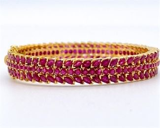 With 22 Carats of round and marquis cut raspberry natural Rubies in 22kts of yellow gold this hinged bangle bracelet is near royalty. The craftmanship is impeccable and the safety clasp helps make sure that your royalties don't slide away. Be sure to bid for this one, you don't it to slide away.