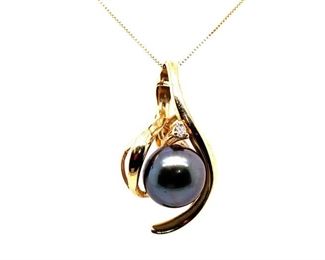 A 10 mm Tahitian Black Pearl is securely wrapped in luscious 14k Yellow Gold and set with a specially selected round diamond to create this masterpiece pendant. Might be a nice match to the ring in Lot 33.
The pearl reaches to the ends of iridescent and right back to a beautiful shinny silky chrome that can never be remade. Each of these wonderous pearl creations is unique and individual. This one is your own, if you are the winning bidder. Chain is not included.