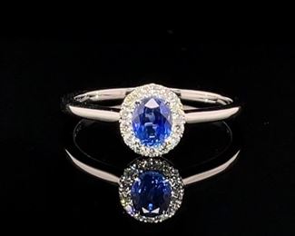 Brand new! Never worn! A stunning, ideal blue natural Sapphire is surrounded by a halo of diamonds and set in a poplar ring style in 14k white gold.