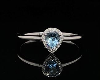 Brand New!! This ring is the perfect spring color of Ski Blue and it shows through this Pear Cut Aquamarine and surrounding Diamonds. The Aquamarine is set around a halo of 17 round cut diamonds and set in shiny new 14k White Gold.