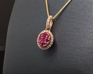Brand New and lovely, this pendant holds natural raspberry colored Rubies that are nestled inside a spectacular shell of diamonds. The pendant is oval shaped much like an egg of the Spring season and framed in glowing 14k Yellow Gold. Chain not included.