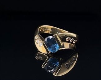 A cool Kashmir Sapphire swims between Bezel set Diamonds set in heavy 14k Yellow Gold. A contemporary design with wonderful sparkle and Kashmir color.