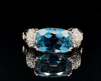 A large, beautiful Blue Topaz set on it's side and surrounded by white topaz in a well designed sterling silver ring.
