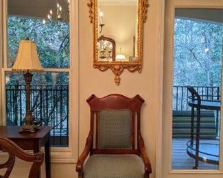 Vintage Italian gilt wood wall mirror, with beveled glass, one of a pair of freshly upholstered mahogany armchairs. 