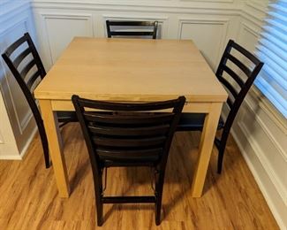 Blonde wood game table, with two leaves that pull out from underneath, with four wooden folding chairs. If you have any social life at all, these wooden folding chairs are great to have around for parties and those unexpected Facebook friends who just "drop by because they were int he neighborhood". 