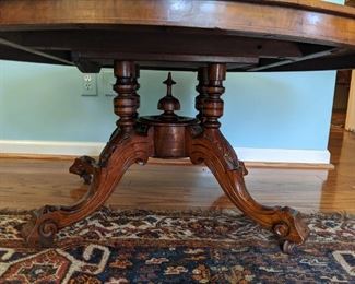 Detail of the intricately carved base of the antique English inlaid/burl walnut coffee table.