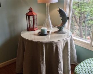 Nice linen fabric on the round bedside table, copper fish, piped as a water feature, swirl glass table lamp and red metal lantern, for that exquisite homey touch. 