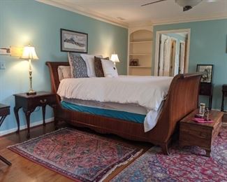 Queen size mahogany sleigh bed, with linens/pillows, mahogany single drawer nightstand, with cabriole leg, vintage cedar chest and hand woven Persian rugs. 